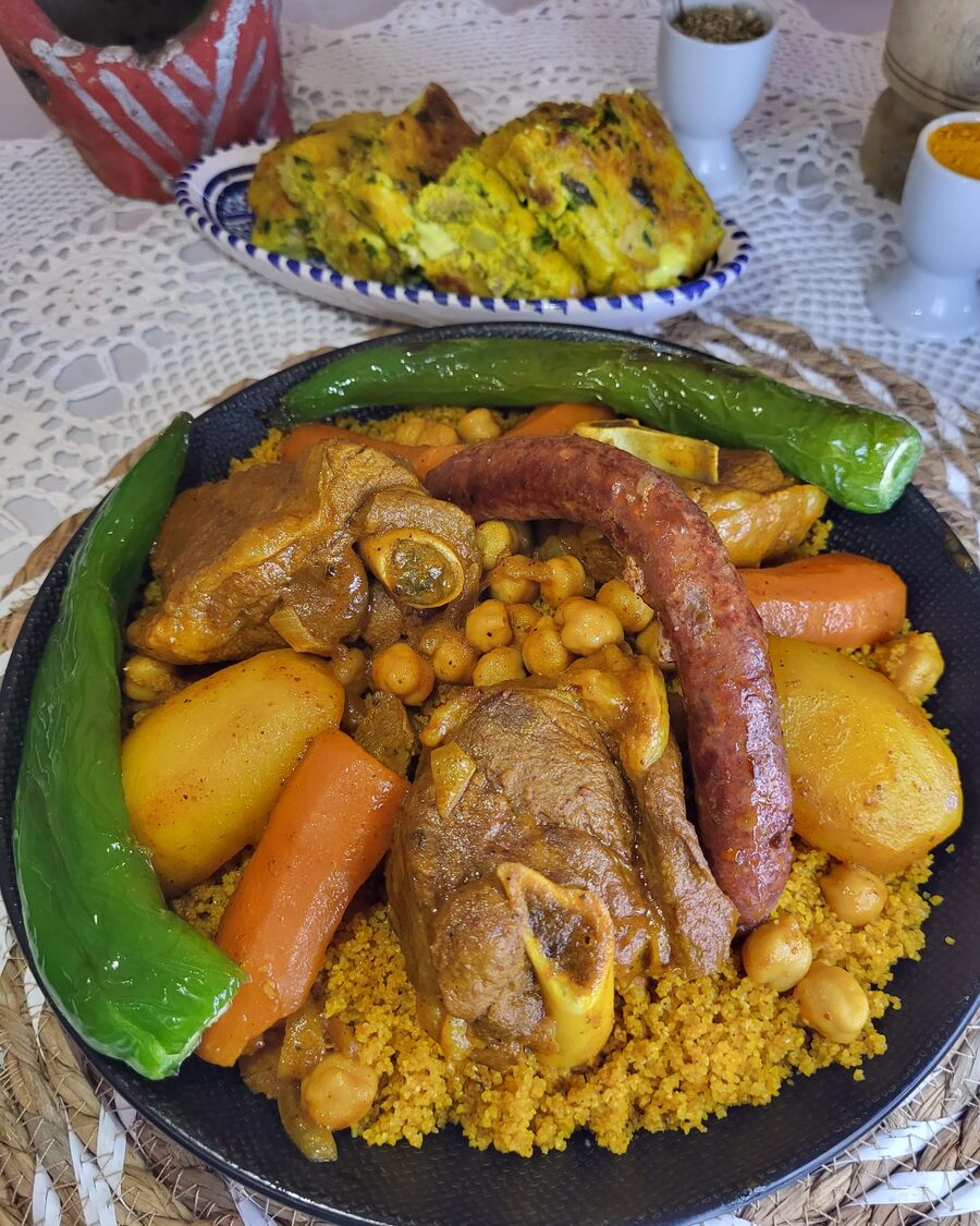 Couscous poulet merguez servi dans un plat, avec merguez, carottes et courgette
